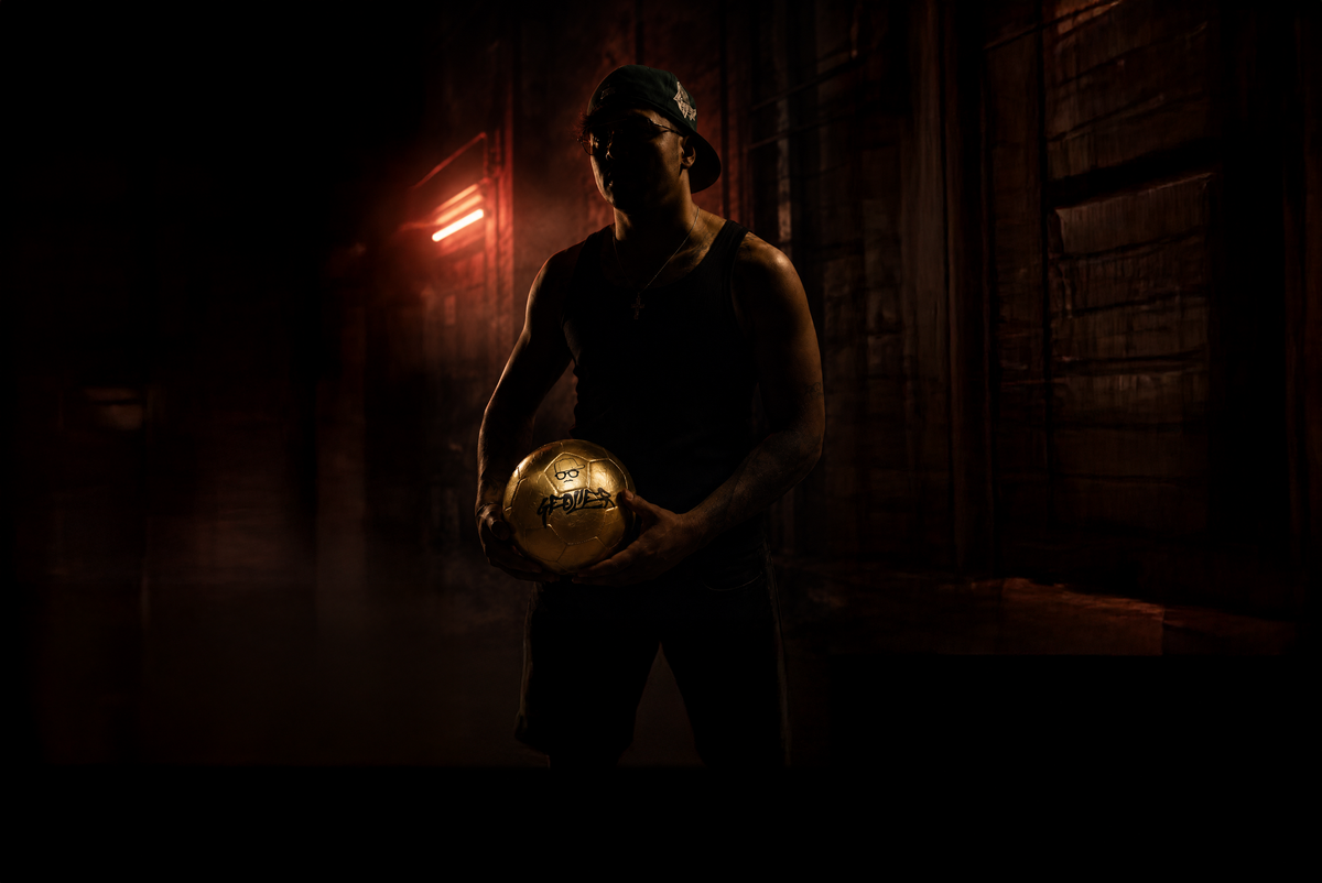 Geolier con il Pallone Geolier dorato in un vicolo illuminato al neon